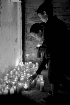 Ofrenda de velas a Santa Bárbara de una madre y su hijo